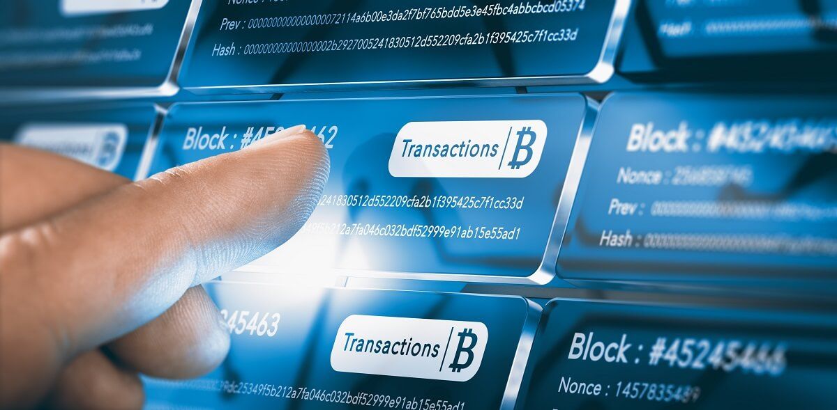 Cryptocurrency Tracing - Finger pressing a block chain block with the text transaction, a bitcoin symbol and security sha256 algorithm hach. Composite between a hand photography.