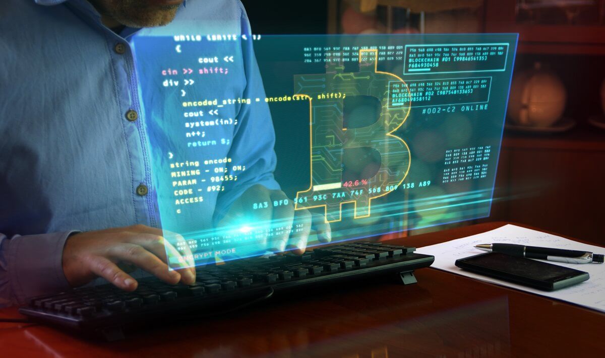Is Bitcoin Traceable? Hacker typing on the keyboard and Bitcoin mining on hologram screen on desk. Digital crypto currency, cyber money and digital banking concept.